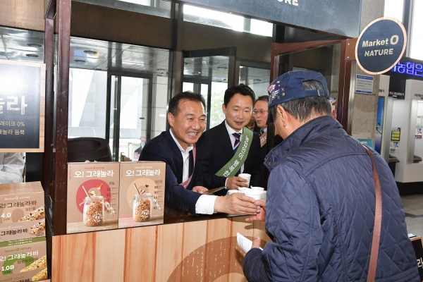 지난15일 서울시 중구 NH농협은행 광화문금융센터에서 NH농협은행 이창호 마케팅부문장과 오리온 김기태 본부장이 내점고객에게 ‘오!그래놀라 시식행사’를 진행하고 있다.