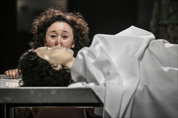 서울시극단의 ‘유령’ 결말 부분에 이르면 배우가 피우던 담뱃불이 막에 옮겨붙는다. 이때 시체 안치소에서 무연고자의 시체 세 구가 꺼내져 무대 앞에 배치되고 안녕사(安寧師)가 등장해 장례를 주관한다. 그에 따라 유령들이 자신의 시체와 작별 인사를 하면 무대 감독이 시체에 불을 붙인다. 사진=서울시극단.