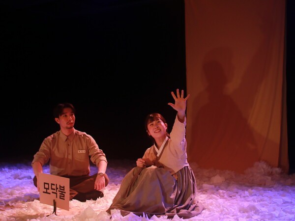 김현규 연출은 연극 '혜영에게' 작품을 감성을 자극하는 연애소설의 형식이나 단계적인 서사 구조로 접근하지 않는다.때로는 우체부 정우가 혜영을 바라보며 2인칭 시점으로 말을 걸기도 하고 서사극적 메타구조로 혜영과의 그루터기 편지 기억을 환기시키기도 하는데 시점은 정우의 회상과 기억을 따라가면서도 1958년도의 시간에 머물러 있다.프롤로그부터 연극임을 환기시키며 관객 참여를 적극적으로 유도한다. 사진=김건표 교수.